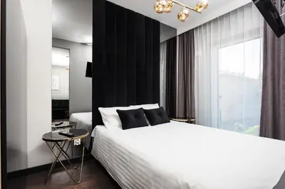 a bedroom with a white bed and a black wall at City of the Kings - Onyks Apartment in Kraków