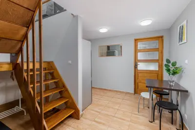 a room with a staircase and a table and chairs at Flat With Cosy Attic - Castle Round the Corner - by Upstairs in Kraków