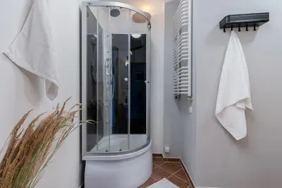 a shower with a glass door in a bathroom at Flat With Cosy Attic - Castle Round the Corner - by Upstairs in Kraków