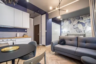 a kitchen and a living room with a table and a couch at Charming apartment in the Old Town in Kraków