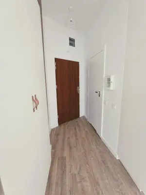 an empty hallway with a door and a wooden floor at 34m2 apartament w centrum Krakowa in Kraków