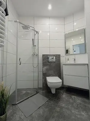 a bathroom with a glass shower and a toilet at 34m2 apartament w centrum Krakowa in Kraków