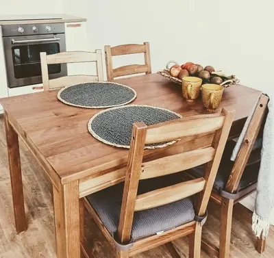 a wooden table with chairs and a bowl of fruit at 34m2 apartament w centrum Krakowa in Kraków