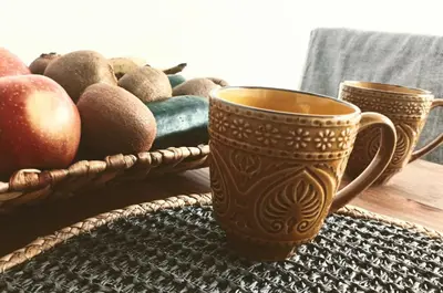 a table with two cups and a basket of fruit at 34m2 apartament w centrum Krakowa in Kraków