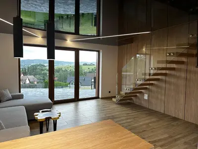 a living room with a couch and a large window at Domki pod Luboniem in Rabka