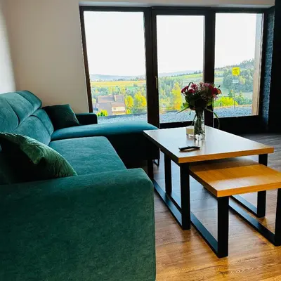 a living room with a couch and a table at Domki pod Luboniem in Rabka