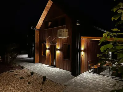 a building with lights on the side of it at night at Domki pod Luboniem in Rabka