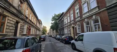 a street with cars parked on the side of the road at Apartment na Zamkowej in Kraków