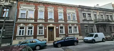 three cars parked in front of a brick building at Apartment na Zamkowej in Kraków