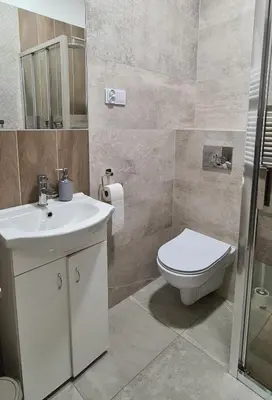 a bathroom with a white sink and a toilet at Apartment na Zamkowej in Kraków