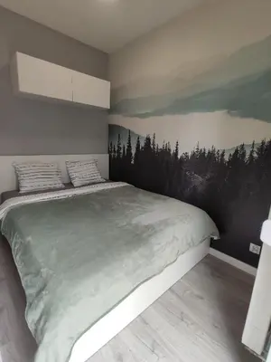a bedroom with a large bed with a painting on the wall at Nowoczesny apartament dla par in Kraków