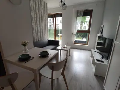 a living room with a table and a couch at Nowoczesny apartament dla par in Kraków