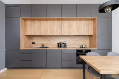 a kitchen with gray cabinets and a wooden table at Modern & Spacious Apartment with Air Conditioning & Parking by Renters Prestige in Kraków