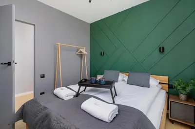a bedroom with two beds with a green wall at Modern & Spacious Apartment with Air Conditioning & Parking by Renters Prestige in Kraków