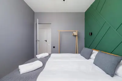 a bedroom with a large bed with a green headboard at Modern & Spacious Apartment with Air Conditioning & Parking by Renters Prestige in Kraków