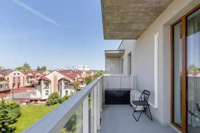 a balcony with a chair and a view of buildings at Modern & Spacious Apartment with Air Conditioning & Parking by Renters Prestige in Kraków
