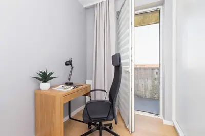 a desk and a chair in a room with a window at Modern & Spacious Apartment with Air Conditioning & Parking by Renters Prestige in Kraków