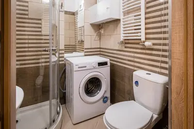 a bathroom with a toilet and a washing machine at Koletek 7 Apartment near the Wawel Castle in Kraków