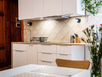a kitchen with white cabinets and a table at Koletek 7 Apartment near the Wawel Castle in Kraków