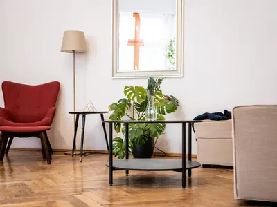 a living room with a chair and a table with a plant at Koletek 7 Apartment near the Wawel Castle in Kraków