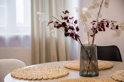 a vase with flowers in it sitting on a table at Koletek 7 Apartment near the Wawel Castle in Kraków