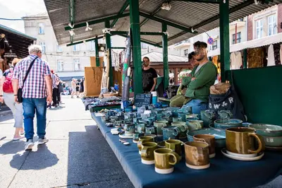 a table with a bunch of pots on it at a market at City Lights Skawińska in Kraków