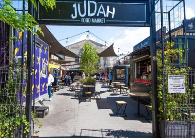 a street with tables and chairs and a sign that reads julia food market at City Lights Skawińska in Kraków