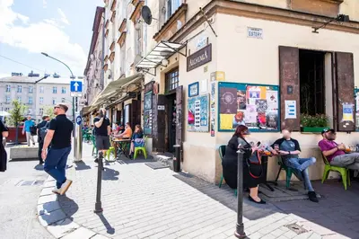 a group of people sitting outside of a building at City Lights Skawińska in Kraków