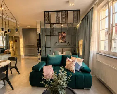 a living room with a green couch and a table at City Lights Skawińska in Kraków