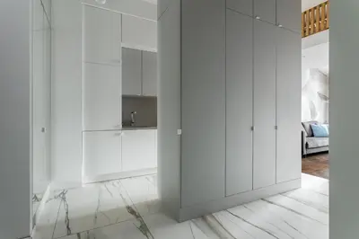 a white kitchen with white cabinets and a sink at Premium Apartment in Kossak Residence in Kraków