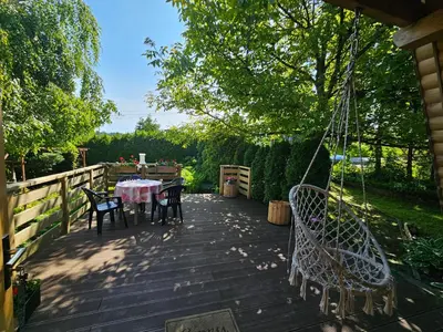a patio with a table and chairs on a deck at LESNA CHATA - jestesmy 15km od Energylandii, domek wolnostojacy, Beskid Maly in Zagórnik