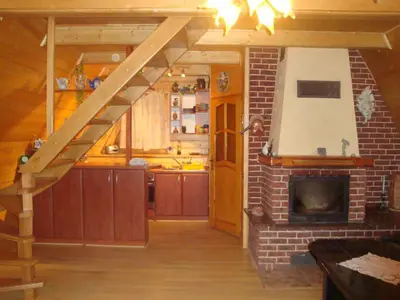 a living room with a kitchen and a fireplace at LESNA CHATA - jestesmy 15km od Energylandii, domek wolnostojacy, Beskid Maly in Zagórnik