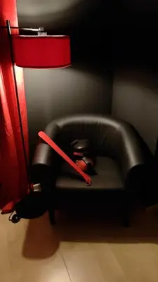 a chair with a red stick on it next to a lamp at BDSM Elysium Playsuite in Kraków