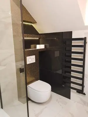 a bathroom with a toilet and a black wall at Mieszkanie do wynajęcia in Stróża