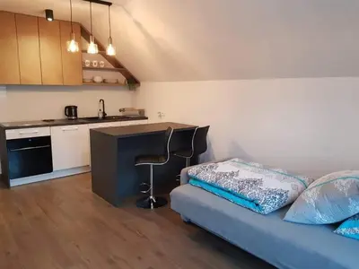 a room with a bed and a kitchen with a counter at Mieszkanie do wynajęcia in Stróża