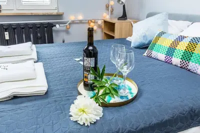 a bottle of wine and glasses on a blue table at Serene Apartment in the City Center - by Upstairs in Kraków