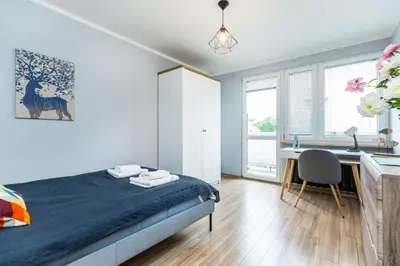a bedroom with a bed and a desk with a chair at Serene Apartment in the City Center - by Upstairs in Kraków