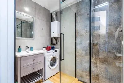 a bathroom with a washing machine and a shower at Serene Apartment in the City Center - by Upstairs in Kraków