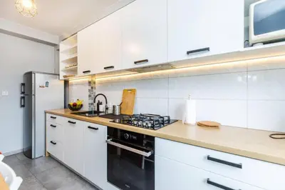 a kitchen with white cabinets and a stove top oven at Serene Apartment in the City Center - by Upstairs in Kraków