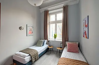 two beds in a room with a window at Urban Nest Apartments Gertrudy 7 in Kraków
