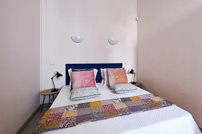 a bedroom with a bed with colorful pillows on it at Urban Nest Apartments Gertrudy 7 in Kraków