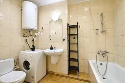 a bathroom with a washing machine and a sink at Urban Nest Apartments Gertrudy 7 in Kraków