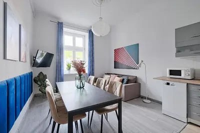 a kitchen and a living room with a table and chairs at Urban Nest Apartments Gertrudy 7 in Kraków