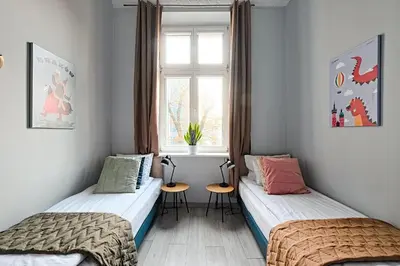 two beds in a room with a window at Urban Nest Apartments Gertrudy 7 in Kraków