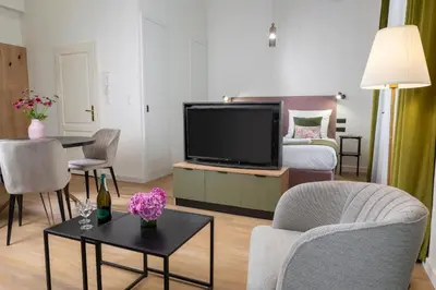 a living room with a flat screen tv and a bed at Rajska Residence in Kraków