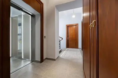 a hallway with a wooden door and aoyer with a glass door at Rajska Residence in Kraków