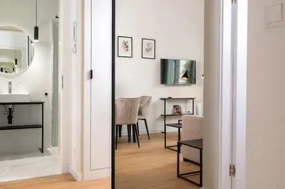 a room with a mirror and a table and chairs at Rajska Residence in Kraków