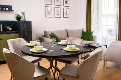 a dining room with a black table and chairs at Rajska Residence in Kraków