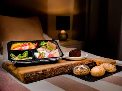 a tray of food on a table with bread and fruit at Rajska Residence in Kraków