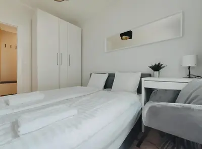 a white bedroom with a bed and a couch at Spasowskiego 2 by Homeprime in Kraków